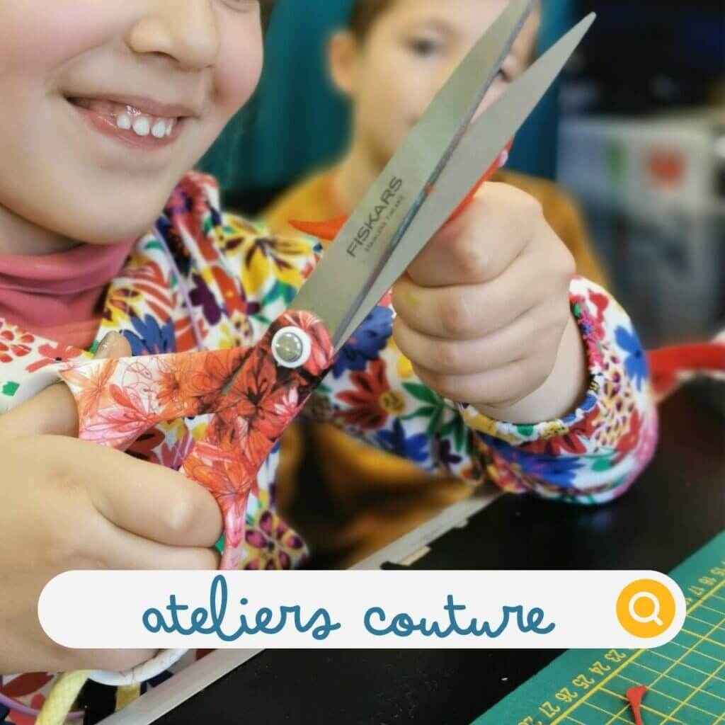 atelier couture fillette en train de découper un morceau de tissu