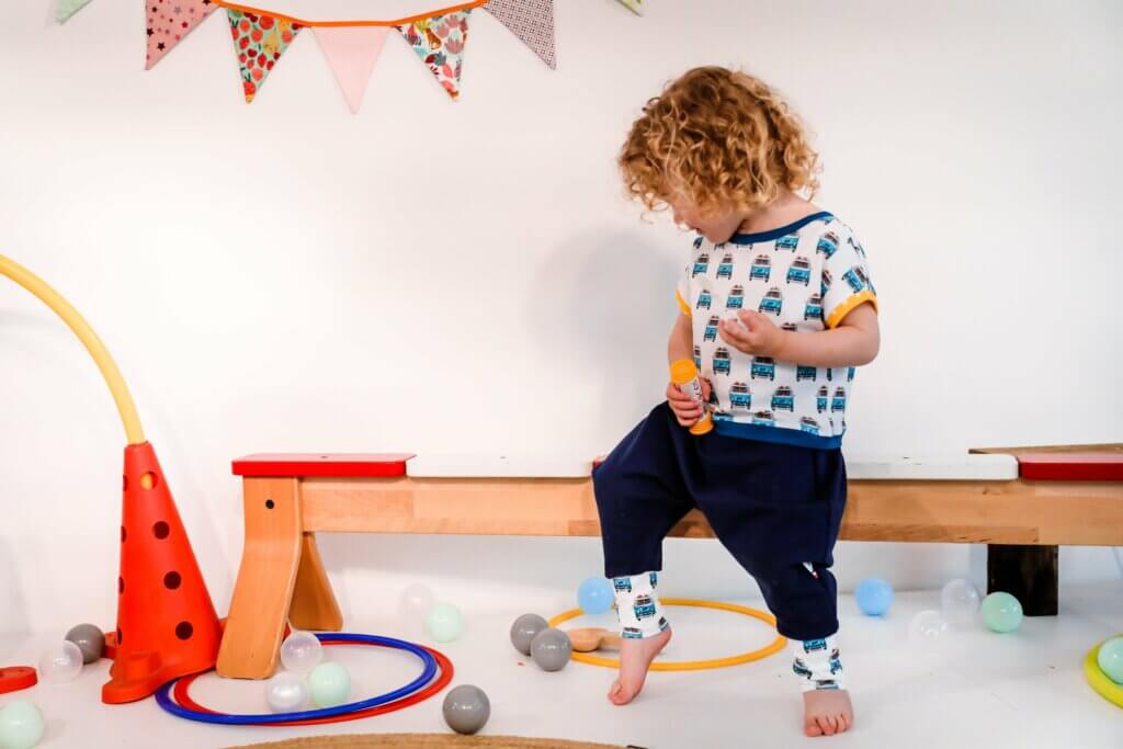 petit garcon qui porte un pantalon souple et evolutif dans une salle de psychomotricité, atelier d'eveil moteur